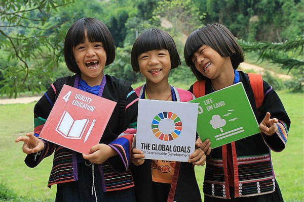3 young girls holding UN Educational cards.